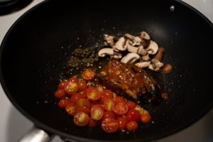 sardines mushrooms and capers being cooked on frying pan