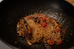 Noodles stirred in frying pan
